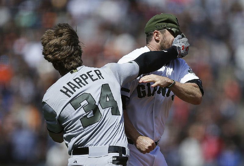 Washington outfielder Bryce Harper (left) lands a right hand to the face of San Francisco relief pitcher Hunter Strickland during the eighth inning of Monday’s game. Harper charged the mound after Strickland hit him in the right hip with a 98-mph fastball. The players exchanged punches, with Strickland connecting first before Harper’s response. The benches and bullpens emptied, with both players eventually being ejected from the game.
