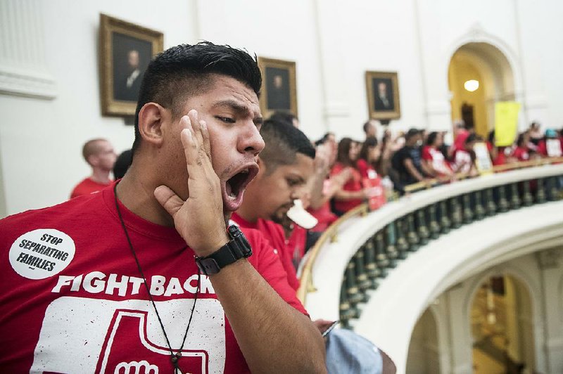 Pedro Paredes joins hundreds of protesters Monday on the balconies of the Texas Capitol rotunda in Austin in a demonstration against the state’s new immigration law.  