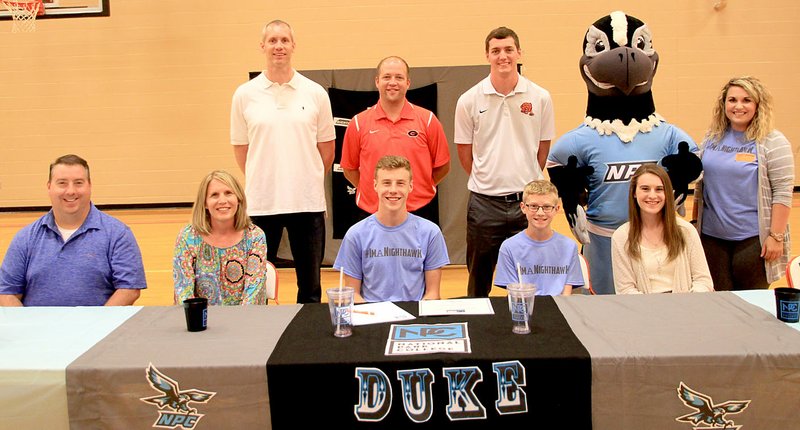 Submitted Photo Seth Duke signed his letter of intent on May 10 during a ceremony at Gravette High School to play basketball at National Park College in Hot Springs. Seth was a senior point guard for the Gravette Lions, which finished 21-8 this past season. He is pictured with his family, his GHS coaches, the Nighthawk Mascot and a representative from National Park College: Grant Duke (front, left), Hope Duke, Seth Duke, Michael Duke, Ella Duke, Coach Doug Batie (row two, left), Coach Matt Busch, Coach Andrew Vire, Nighthawk Mascot and NPC Rep. Chelsea Lairamore.