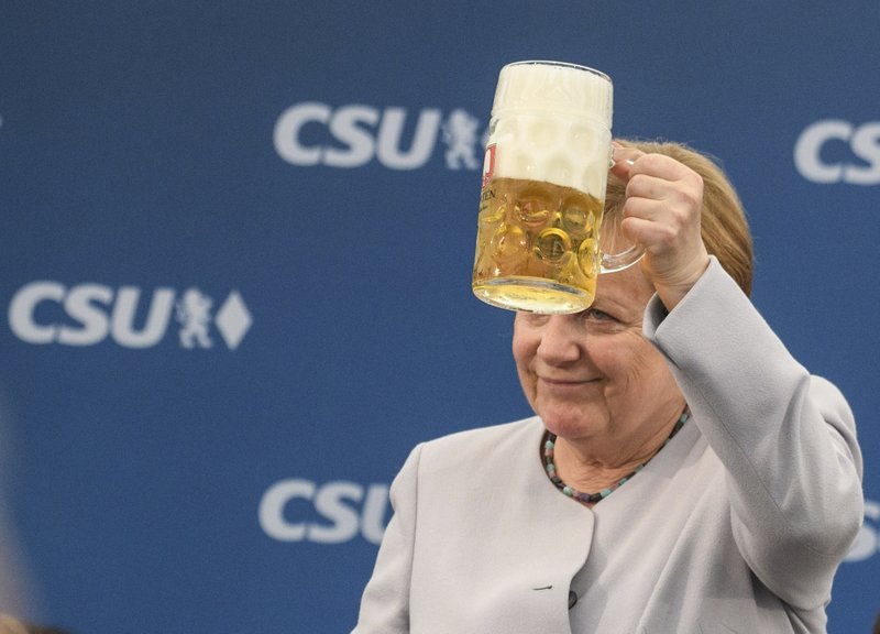 German Chancellor Angela Merkel lifts a glass of beer during an election campaign of her Christian Democratic Union, CDU, and the Christian Social Union, CSU, in Munich, southern Germany, Sunday, May 28, 2017. A poll of German voters shows Chancellor Merkel's conservative bloc's lead widening as the main challenger Social Democrats continue to lose support. (Matthias Balk/dpa via AP)