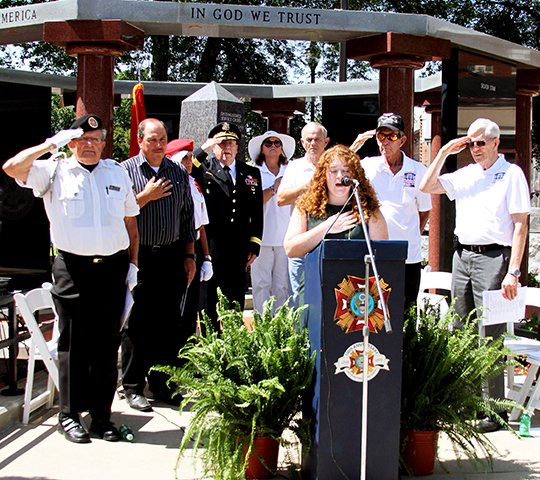 The Sentinel-Record/Grace Brown LAND OF THE FREE: Amy Arego sings the national anthem Monday during the community's annual Memorial Day Service at the Garland County Veterans Memorial and Military Park.