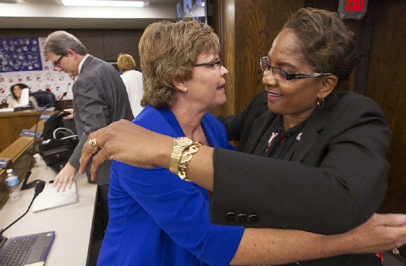 Valerie Tatum (right), founder and superintendent of the Covenant Keepers charter school, hugs Ouida Newton as she thanks Newton and other members of the Arkansas Board of Education for their vote keeping the school in operation.