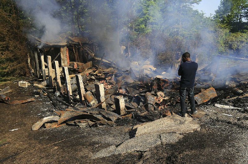 Richard Gilliam looks over the remains of the landmark after it burned early Tuesday. Gilliam grew up in the area and once worked at the restaurant.