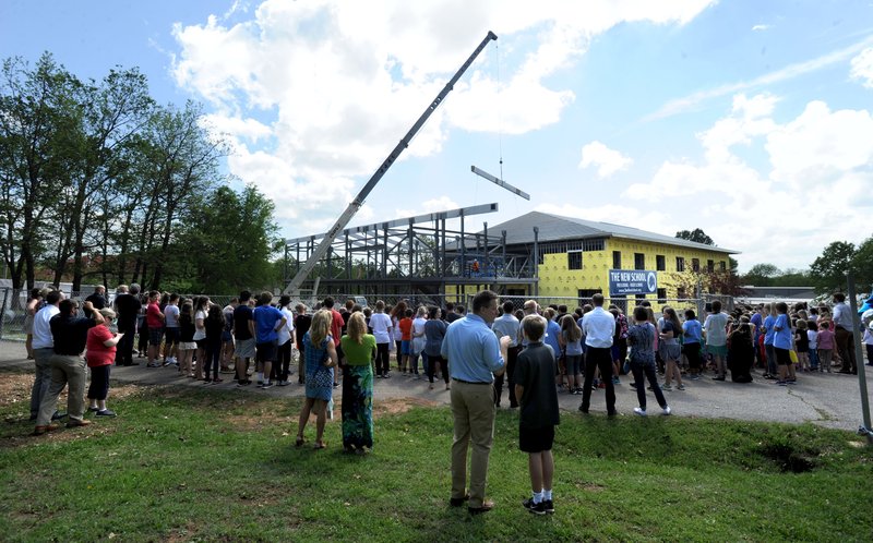 NWA Democrat-Gazette/ANDY SHUPE A large crowd of students, teachers, administrators and parents at The New School gather to watch as a large wooden beam is raised by a crane onto the school's Innovation Center during a topping out ceremony and tour of the school's expansion project in Fayetteville. The New School hopes to open the facility in the fall for the 2017-18 school year.