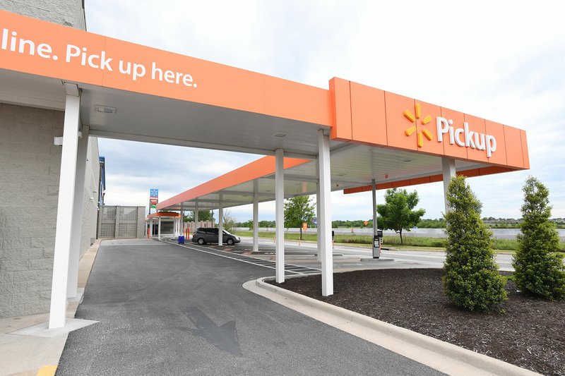 NWA Democrat-Gazette/J.T. WAMPLER Customers park under an awning to pick up groceries May 3 at Wal-Mart on Pleasant Grove in Rogers.