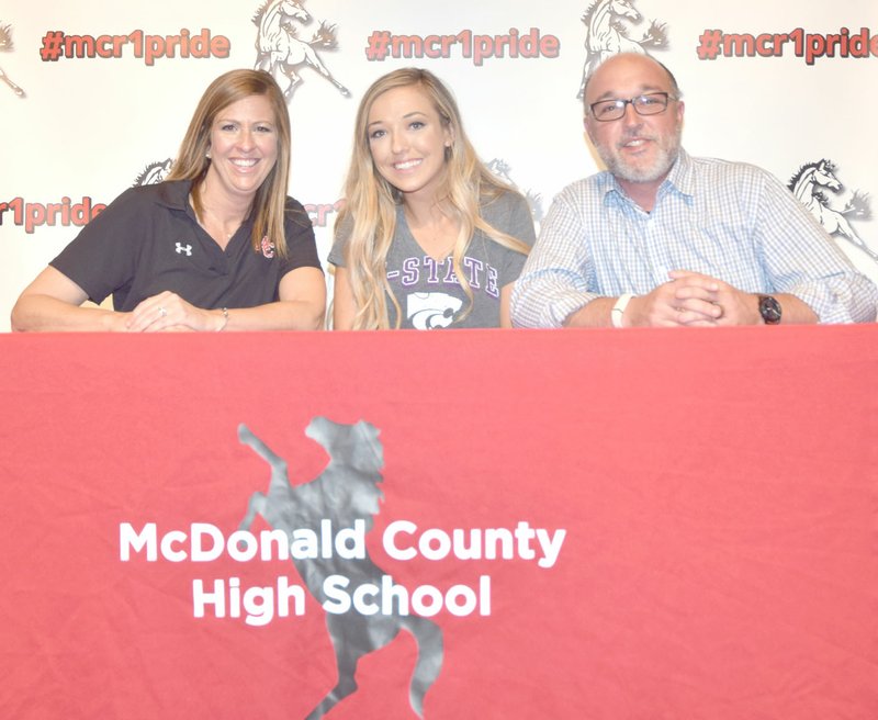 McDonald County High School cheerleader Carlie Dill (center) is flanked by her parents, Jill and Jason Dill, on her signing to cheer at Kansas State University.