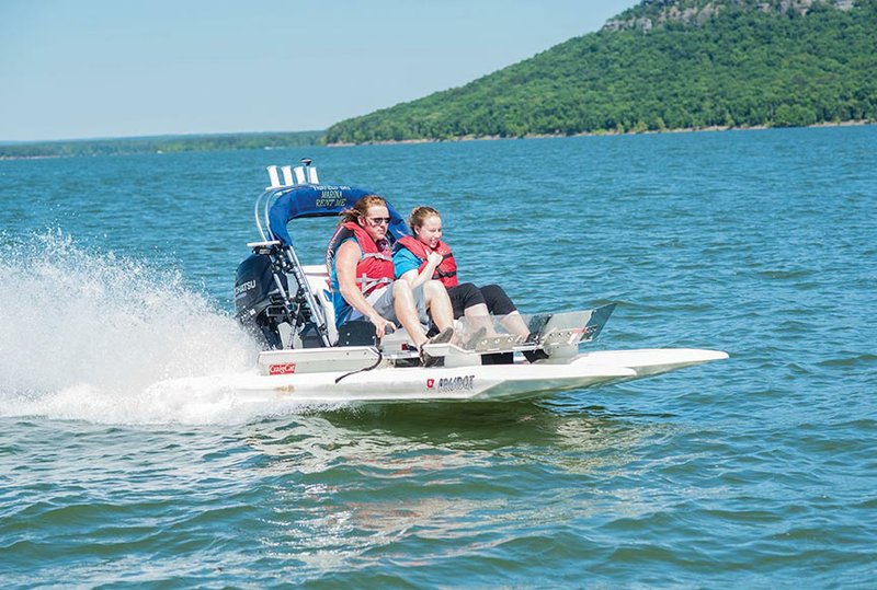 Reed Sutterfield, left, and Amber Lott take the small but fast CraigCat out for a spin on Greers Ferry Lake as they prepare for Surf the Bay in Fairfield Bay. The CraigCat is new to Surf the Bay, and the craft will be available to rent at the festival.