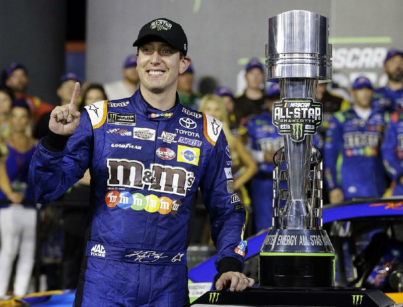 Kyle Busch poses with the trophy in Victory Lane after winning the NASCAR Cup series All-Star auto race at Charlotte Motor Speedway in Concord, N.C., Saturday, May 20, 2017. 