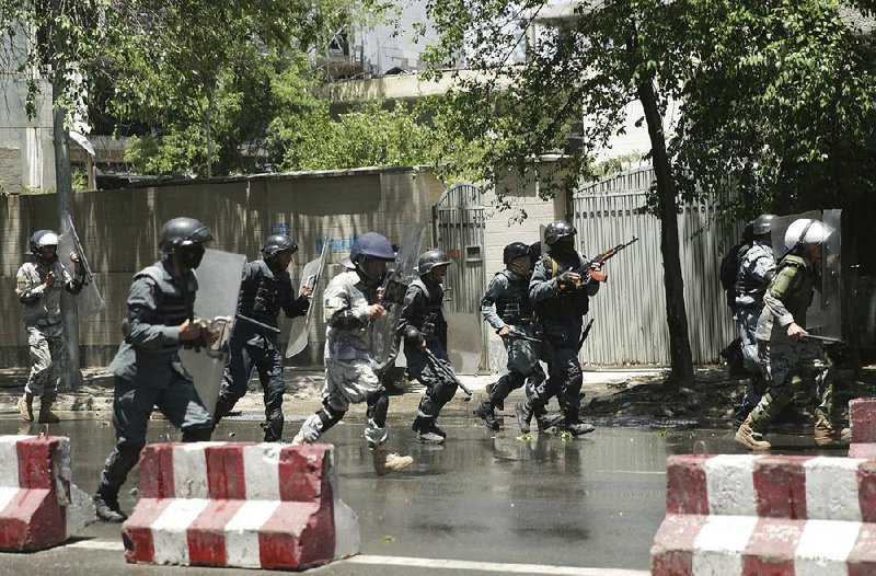 Flying stones force police to flee Friday during a protest in Kabul, Afghanistan. 
