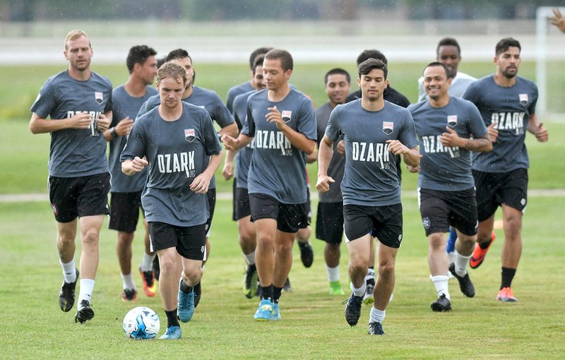 NWA Democrat-Gazette/BEN GOFF @NWABENGOFF Ozark Futbol Club players warm up Thursday at practice at the Sporting Arkansas fields in Centerton. The amateur soccer team is entering it&#8217;s first season competing in the National Premier Soccer League.