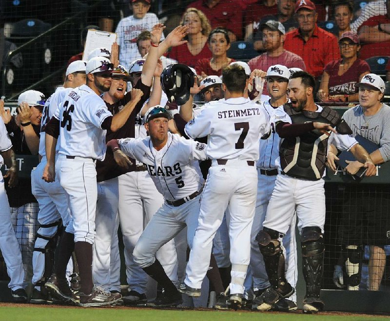 Missouri State’s Hunter Steinmetz (7) is congratulated by teammates after hitting a home run in the fi rst inning against Arkansas on Saturday night in the NCAA Fayetteville Regional. Missouri State won 5-4, sending the Hogs to an elimination game today.