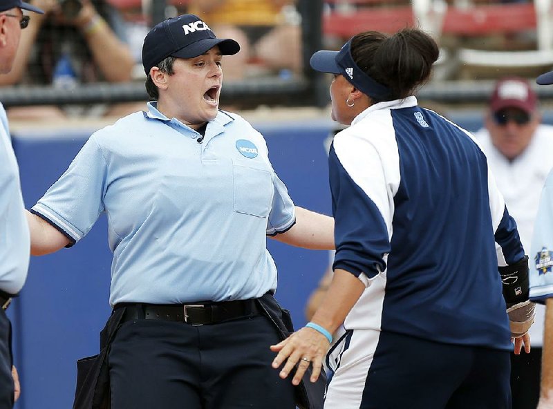 UCLA assistant coach Lisa Fernandez (right) argues with umpire Erin Peterson after a call went against the Bruins in an 8-2 victory over Texas A&M in the Women’s College World Series on Saturday.