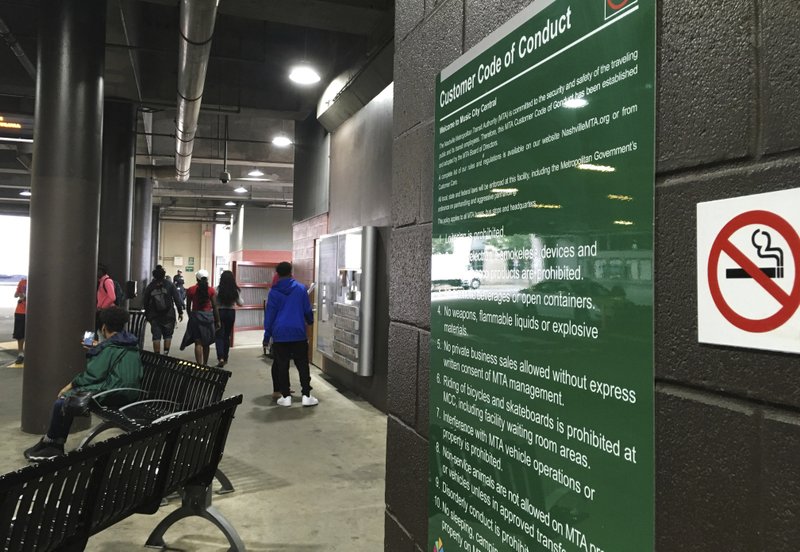 In this May 25, 2017 photo, students look for their buses at Music City Central in Nashville, after a day of school. A sign hangs in the bus station that says weapons aren't allowed. Under a new state law, the station and many other local government properties would have to decide whether to add metal detectors or let handgun permit holders carry their guns around. 