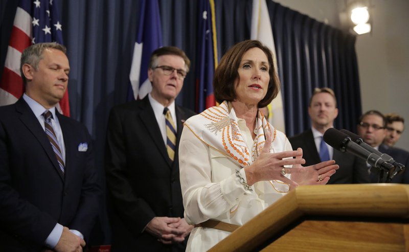 FILE - In this March 6, 2017, file photo, Texas Sen. Lois Kolkhorst, front, backed by Texas Lt. Gov. Dan Patrick, center, and other legislators talks to the media during a news conference to discuss Senate Bill 6 at the Texas Capitol in Austin, Texas.