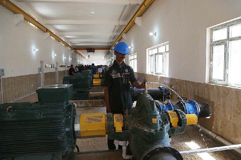 A worker operates machinery in a newly opened water station in Fallujah, Iraq.