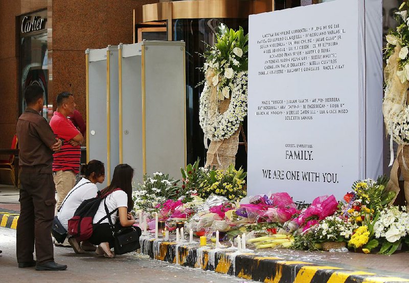 Employees of the Resorts World Manila complex pray Sunday in Pasay, southeast of Manila, at a memorial for the victims of a deadly casino attack by a lone gunman.