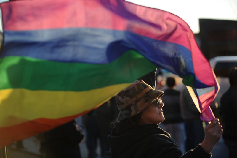 Niki O'Brien of Fayetteville holds a rainbow flag Feb. 24 during a rally in reaction to the Arkansas Supreme Court decision that found the city's nondiscrimination ordinance violates state law.