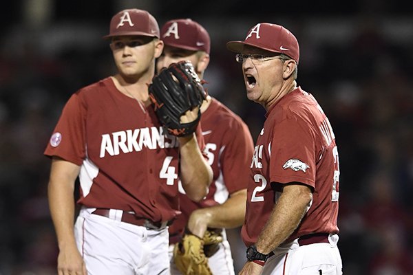Arkansas coach Dave Van Horn, right, calls for a relief pitcher as he visits the mound to talk with pitcher Kevin Kopps (45) in the third inning of an NCAA college baseball regional tournament game against Missouri State in Fayetteville, Ark., Sunday, June 4, 2017. (AP Photo/Michael Woods)

