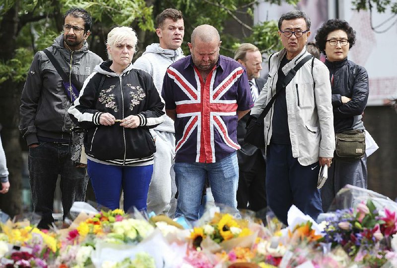 People gather at a makeshift memorial near London Bridge on Monday.