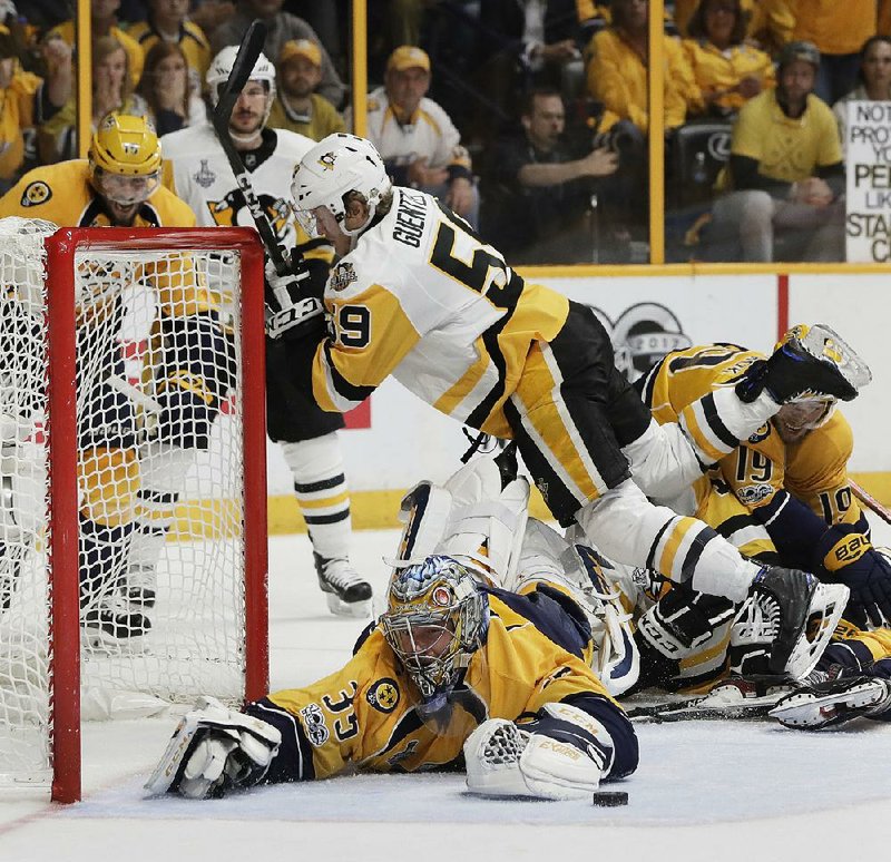 Nashville goalie Pekka Rinne (bottom) dives to stop a shot from Pittsburgh center Jake Guentzel during the second period of Monday night’s game. The Penguins tied the Stanley Cup Final at 2-2 by beating the Penguins 4-1.