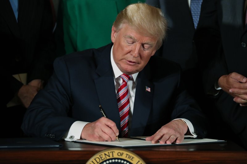 President Donald Trump signs a decision memo and a letter to members of Congress outlining the principles of his plan to privatize the nation's air traffic control system in the East Room at the White House, Monday, June 5, 2017, in Washington. (AP Photo/Andrew Harnik)