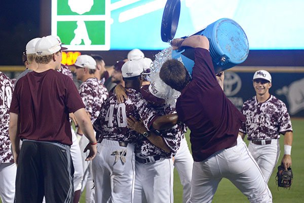 An unidentifiable Missouri State player pours water on coach Keith Guttin following the Bears' 3-2 win over Arkansas in an NCAA Tournament game Monday, June 5, 2017, in Fayetteville. 