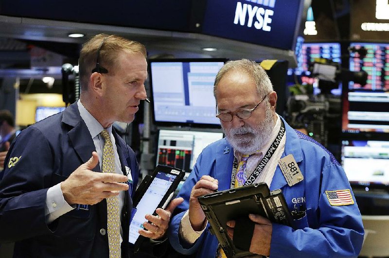 Traders Michael Smyth (left) and Eugene Mauro work Tuesday on the floor of the New York Stock Exchange. 