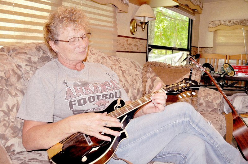 TIMES photograph by Rachel Dickerson Linda Luney of Pea Ridge plays the mandolin in her RV at the Lost Bridge North Park in Garfield.