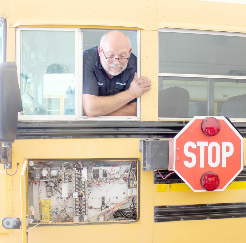 Keith Bryant/The Times of Northeast Benton County
Marion Holland, schoolbus mechanic for Pea Ridge Schools, examines an out-of-commission bus's wiring after making a few adjustments.