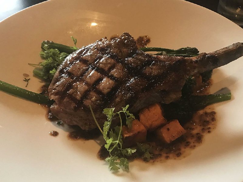 Petit & Keet Bar and Grill’s Bone-in Berkshire Pork Chop is served with roasted sweet potato and sauteed broccolini. 