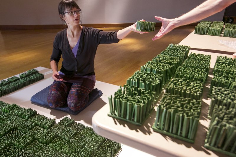 Dawn Holder installs her exhibit of porcelain grass blocks at the Arkansas Arts Center in Little Rock in preparation for the museum's annual Delta Exhibition, which opens Friday.
