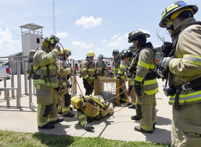 NWA Democrat-Gazette/FLIP PUTTHOFF New firefighters from several departments go through an obstacle course Tuesday at the Rogers Fire Department training center, 3003 W. Oak St.