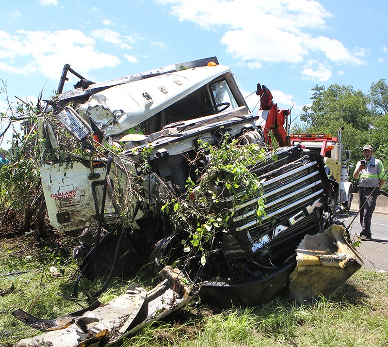 The Sentinel-Record/Richard Rasmussen PULLED OUT: Burks & Mahoney Wrecker Service pulls a Garland County Landfill semitruck up an embankment after it overturned off the eastbound side of the King Expressway on Thursday.