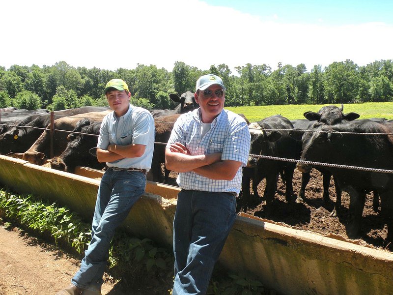 Colton Tharp, left, and his father, Chris Tharp, take a break while feeding cattle on their farm in Floral. The Tharp family, the Independence County Farm Family of the Year, raises mostly Brangus and Angus cattle. They also operate six broiler houses and a commercial litter service.