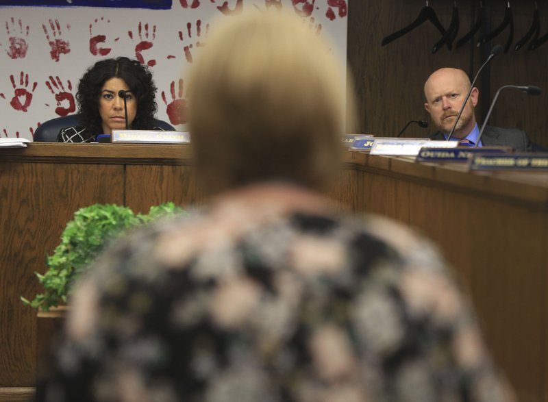 Board Chairman Mireya Reith (left) and board member Jay Barth (right) listen as Bryant Public Schools Deputy Superintendent Karen Walters answers questions Thursday about a requested waiver during a state Board of Education meeting in Little Rock.