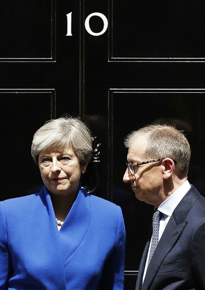 British Prime Minister Theresa May, speaking Friday outside No. 10 Downing St. in London with her husband, Philip, promised to form “a government that can provide certainty.”