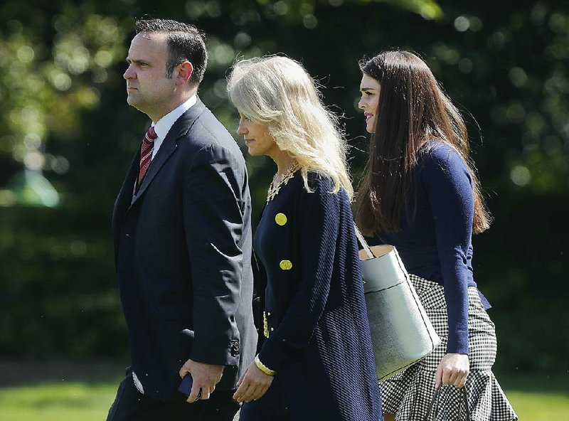 White House aides (from left) Dan Scavino Jr., Kellyanne Conway and Hope Hicks walk across the South Lawn to join President Donald Trump on the presidential helicopter on Friday.