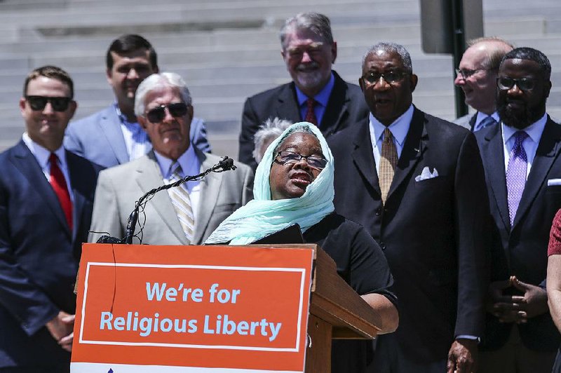 Valerie Bridgeman, interim dean and professor at Methodist Theological School in Ohio, speaks during a rally Friday to support Pulaski County Circuit Judge Wendell Griffen (right), who is facing an ethics investigation by the state Judicial Discipline and Disability Commission after taking part a protest against the death penalty.