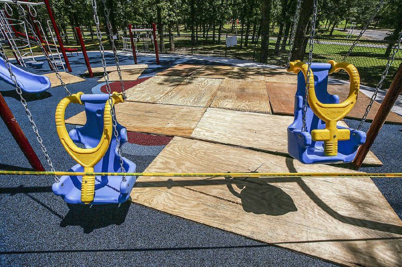 Wooden boards cover a sinkhole that has delayed the grand opening of a newly built playground for special-needs children at Burns Park in North Little Rock.