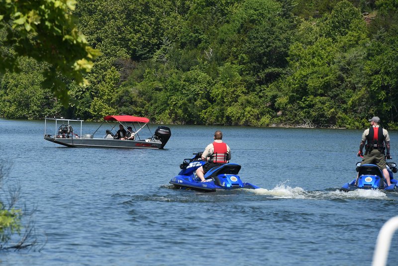 NWA Democrat-Gazette/J.T. WAMPLER Benton County deputies on personal water craft and in a boat search Friday for a Bella Vista man who was reported missing near the Arkansas 12 bridge over Beaver Lake in the Prairie Creek area near Rogers.