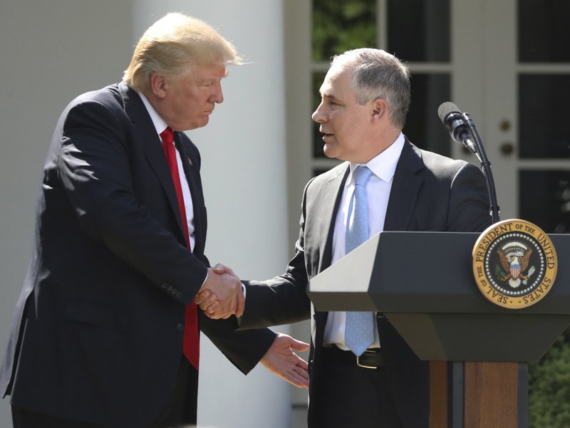 FILE - In this June 1, 2017 file photo, President Donald Trump shakes hands with EPA Administrator Scott Pruitt after speaking about the US role in the Paris climate change accord in the Rose Garden of the White House in Washington. 