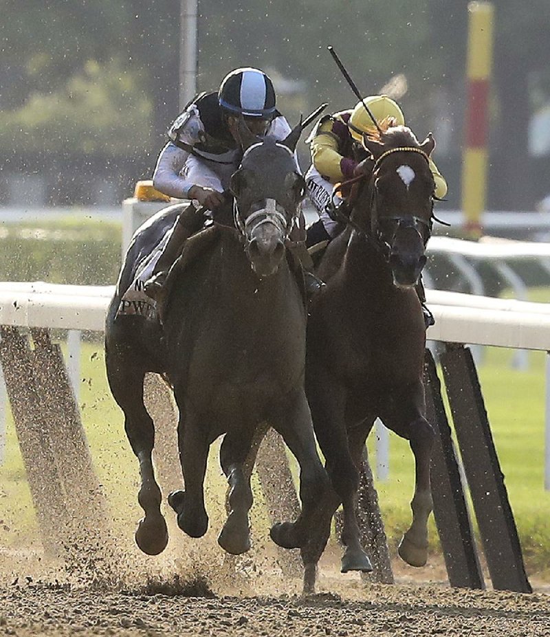 Tapwrit (left), ridden by Jose Ortiz, edges past Irish War Cry and jockey Rajiv Maragh to win the  Belmont Stakes by 2 lengths on Saturday in Elmont, N.Y. Tapwrit’s winning time was 2:30.02.