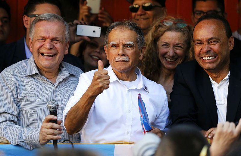 Puerto Rican nationalist Oscar Lopez Rivera (center) reacts to the crowd last month as his brother Jose (left) and U.S. Rep. Luis Gutierrez, D-Ill., join him at a gathering in his honor in Chicago.