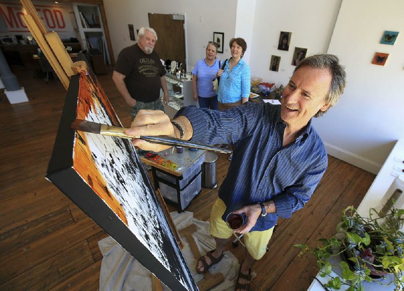 Artist Matt McLeod works on a painting Saturday at the Matt McLeod Fine Art Gallery in Little Rock as visitors (background, from left) Bryan Kellar and Carol and Gayle Corley watch during the Open Studios event.