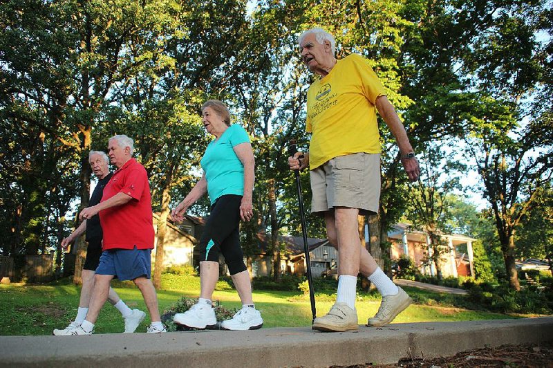 As the sun rises over North Little Rock’s Lakewood Lake No. 3, Joe Dilday, 87 (from left); Drew Hodges, 70; Janet Dilday, 85; and Price Harris, 85, continue a 20-year-old tradition of walking together for mental and physical fitness.