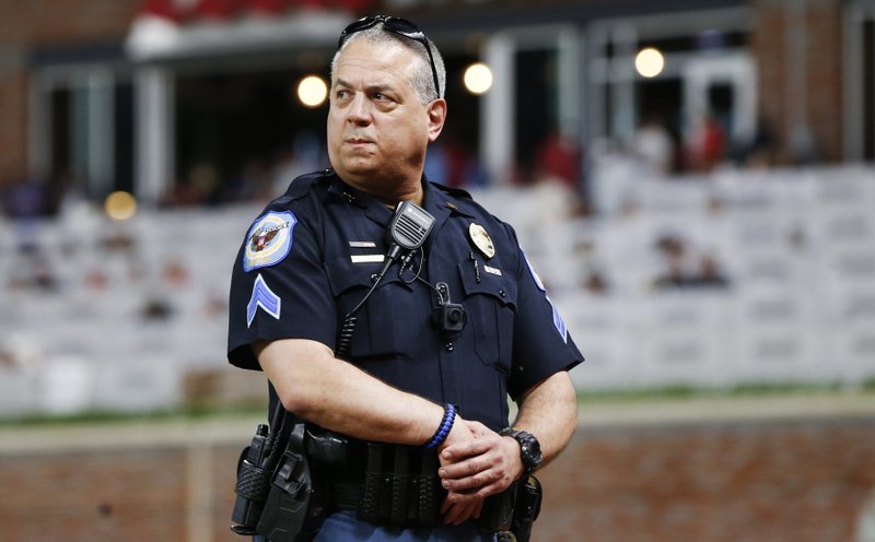 In this Wednesday, May 24, 2017, photo, a Cobb County police officer wears a body camera as he works an off-duty security detail at at an Atlanta Braves baseball game in Atlanta. Most police agencies don't require or won't allow body cameras for off-duty officers working in uniform. Experts said that leaves a big hole in policies designed to increase oversight and restore confidence in law enforcement.