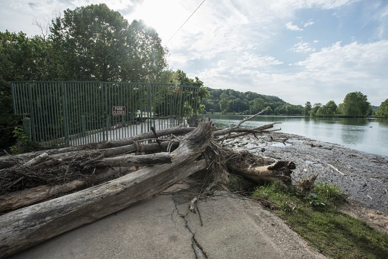 Wood and debris is piled up on top of the dam and against the spillway Friday, May 26, 2017, on Lake Bella Vista. The trail going over the dam has been closed since heave ran flooded the lake and dam earlier this month. 