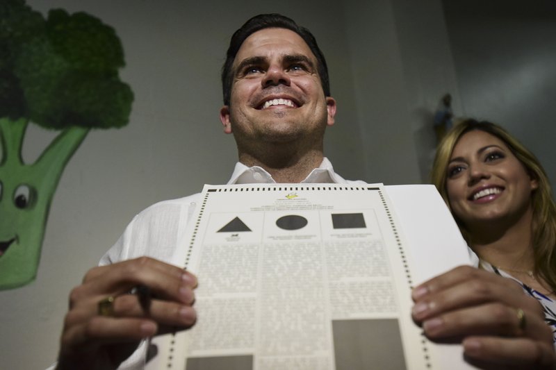 Gov. Ricardo Rossello shows his ballot at the San Jose Academy during the fifth referendum in San Juan, Puerto Rico, Sunday, June 11, 2017. 