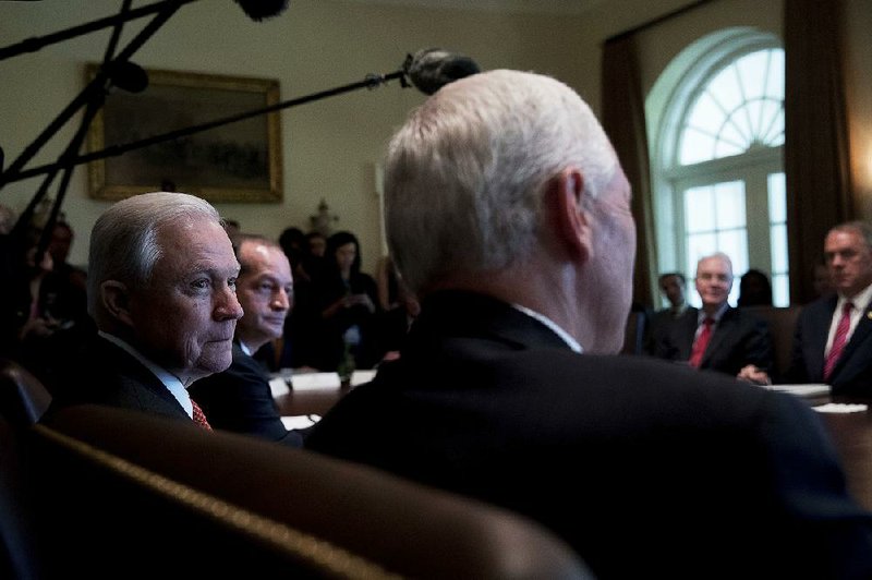 Attorney General Jeff Sessions (left) listens Monday as Vice President Mike Pence speaks during a  White House meeting with members of President Donald Trump’s Cabinet.