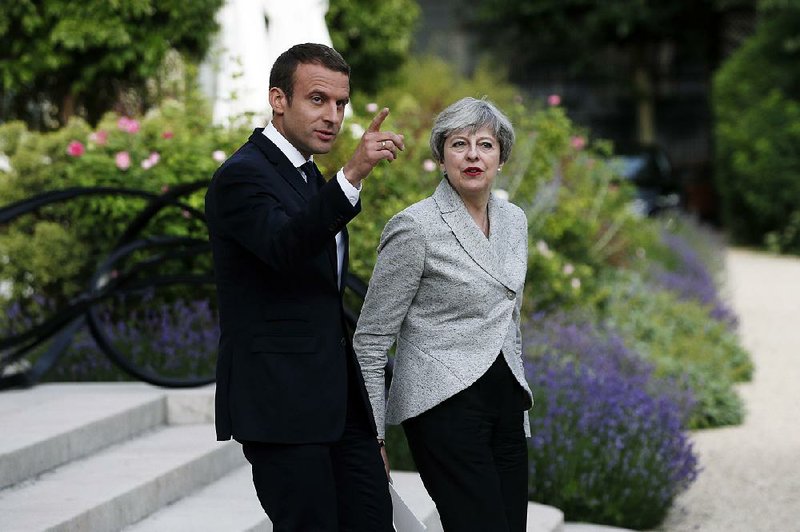 French President Emmanuel Macron and British Prime Minister Theresa May arrive for a joint news conference Tuesday after a meeting at the Elysee Palace in Paris. 